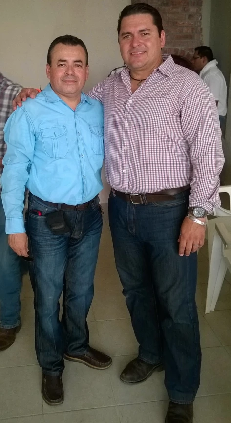 two men wearing blue jeans are standing near each other