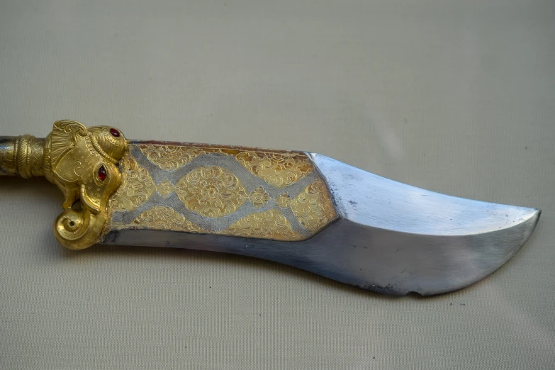 an elaborate gold handle knife that looks like it is being used