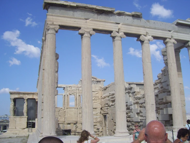 there is a man and a woman standing by some pillars