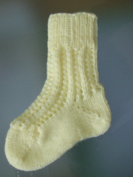 closeup image of someone holding a sock that is knitting