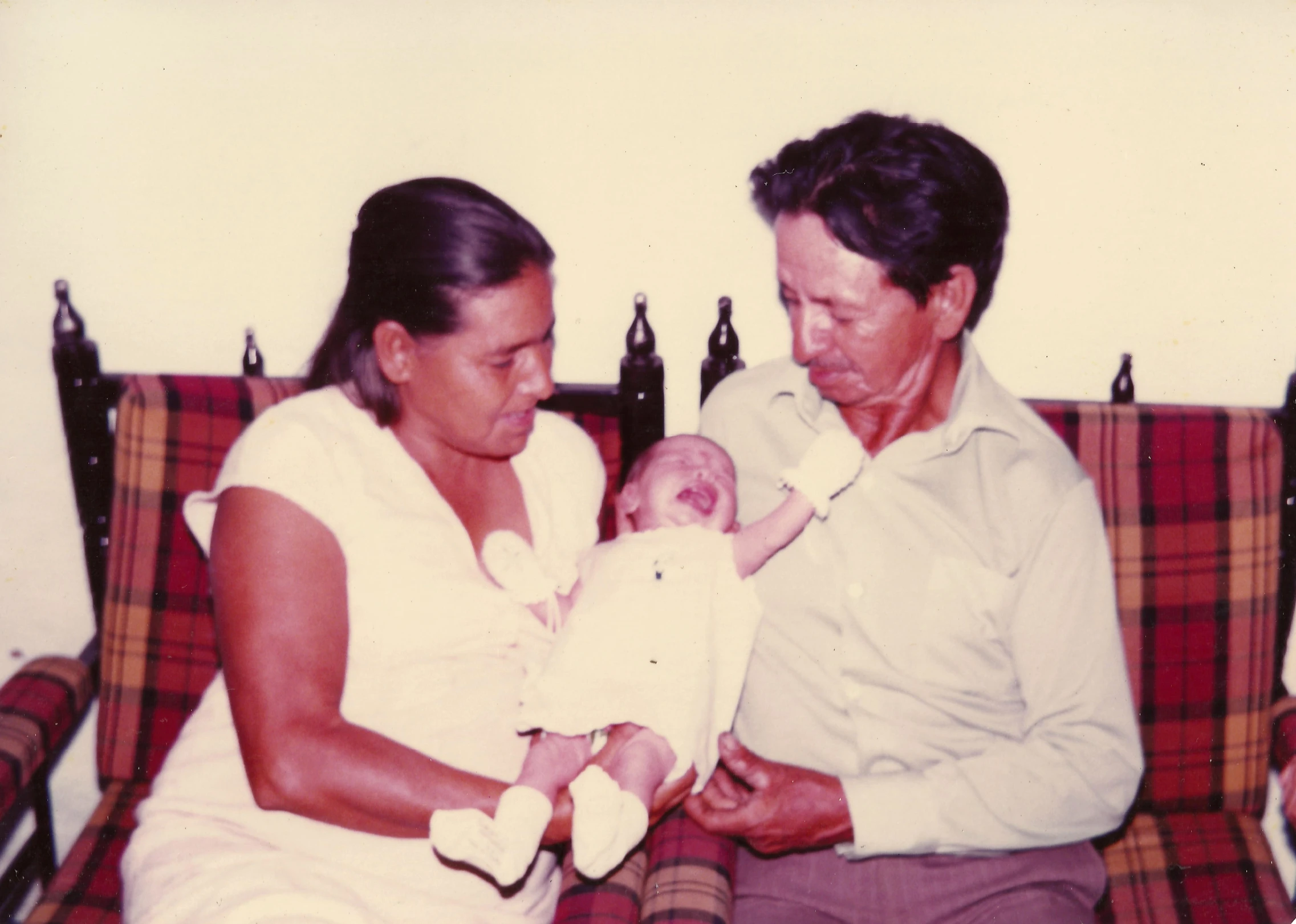 a man holding a baby with his hands on the lap