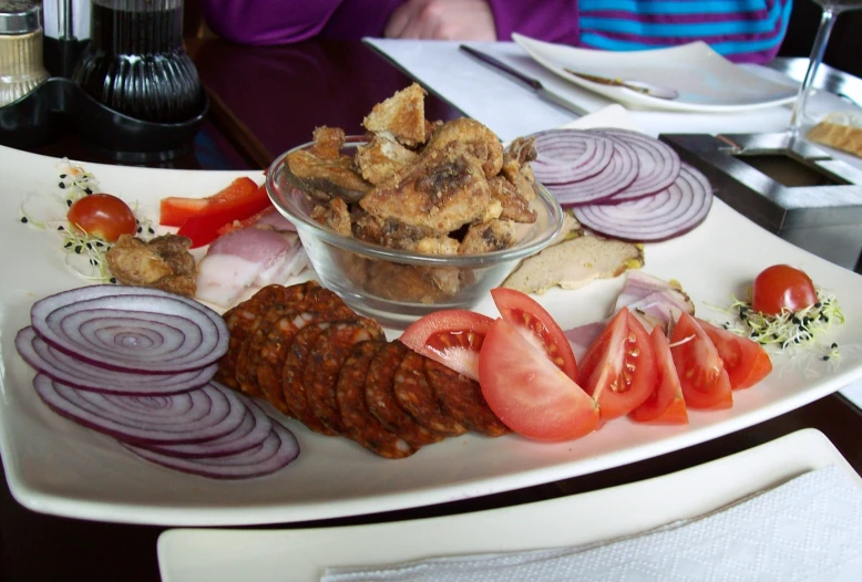 plate of food containing several different meats on it