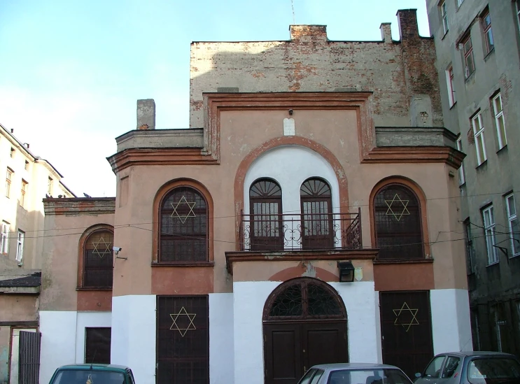 a tall building with many windows near other buildings