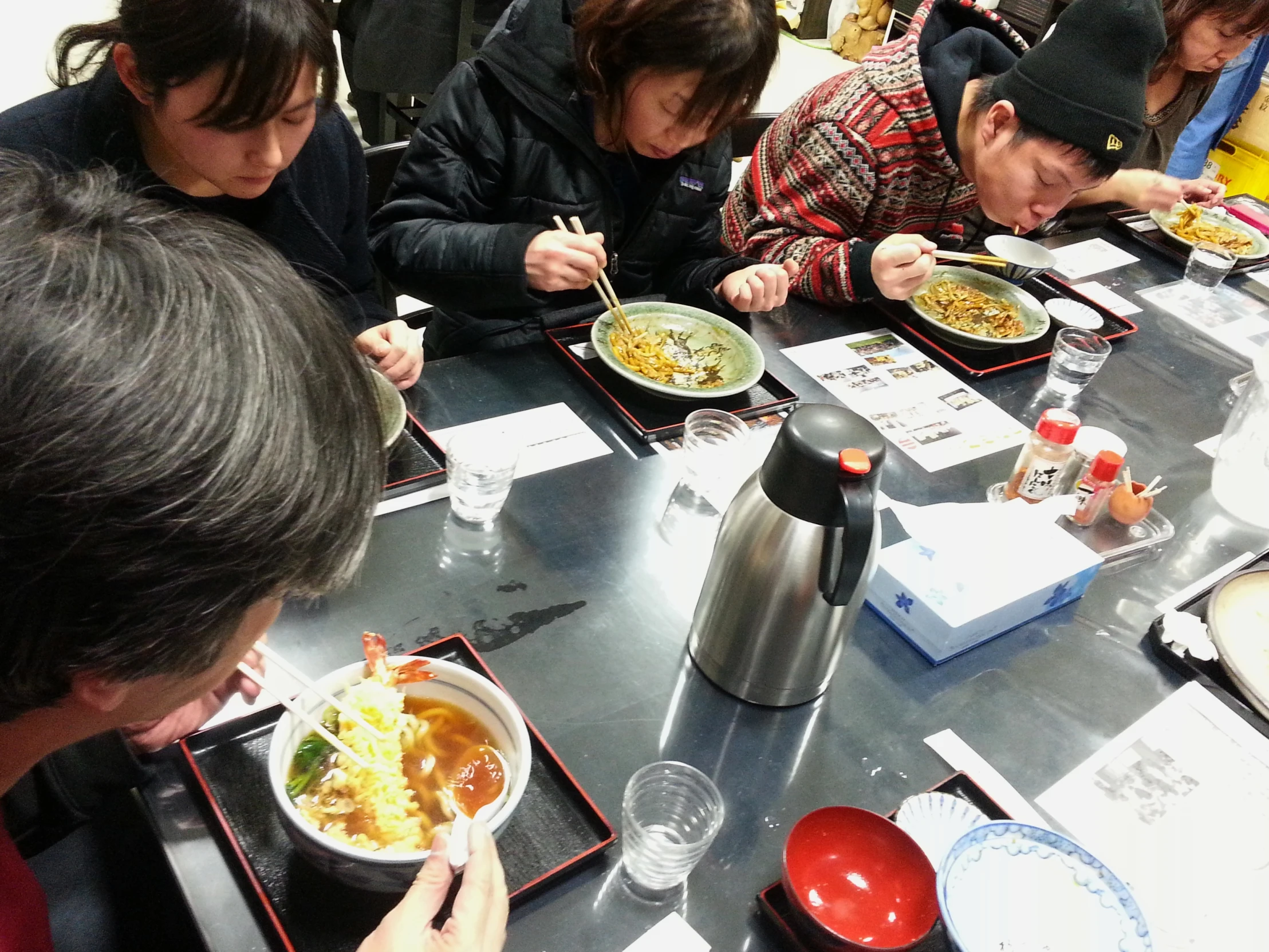 a group of asian people eating in a restaurant