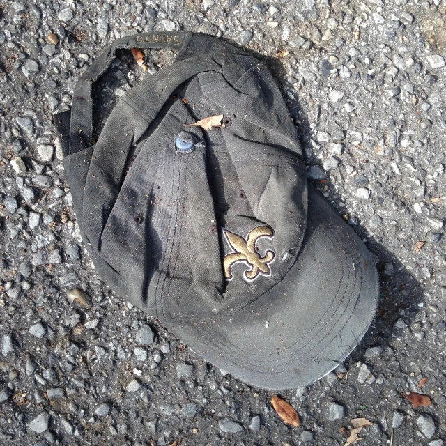 a hat is sitting on the ground with gravel