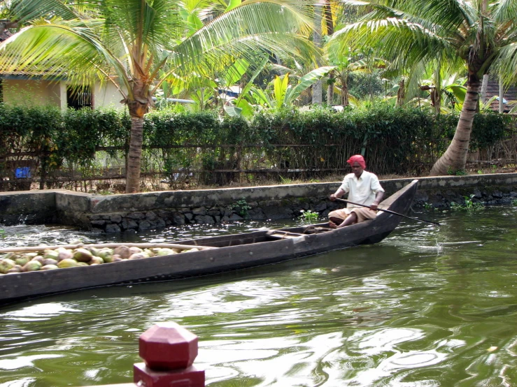 a man rowing a boat through some shallow water