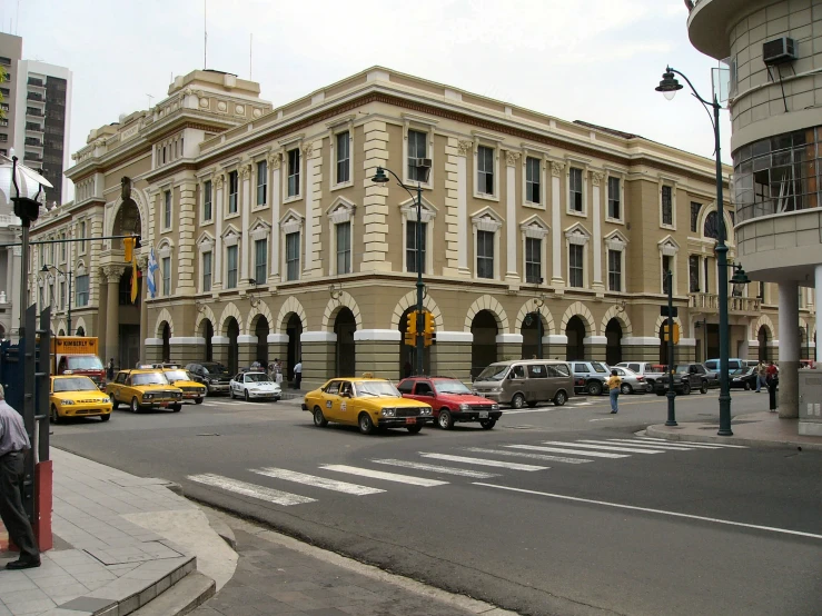 a city intersection with cars and pedestrians passing by