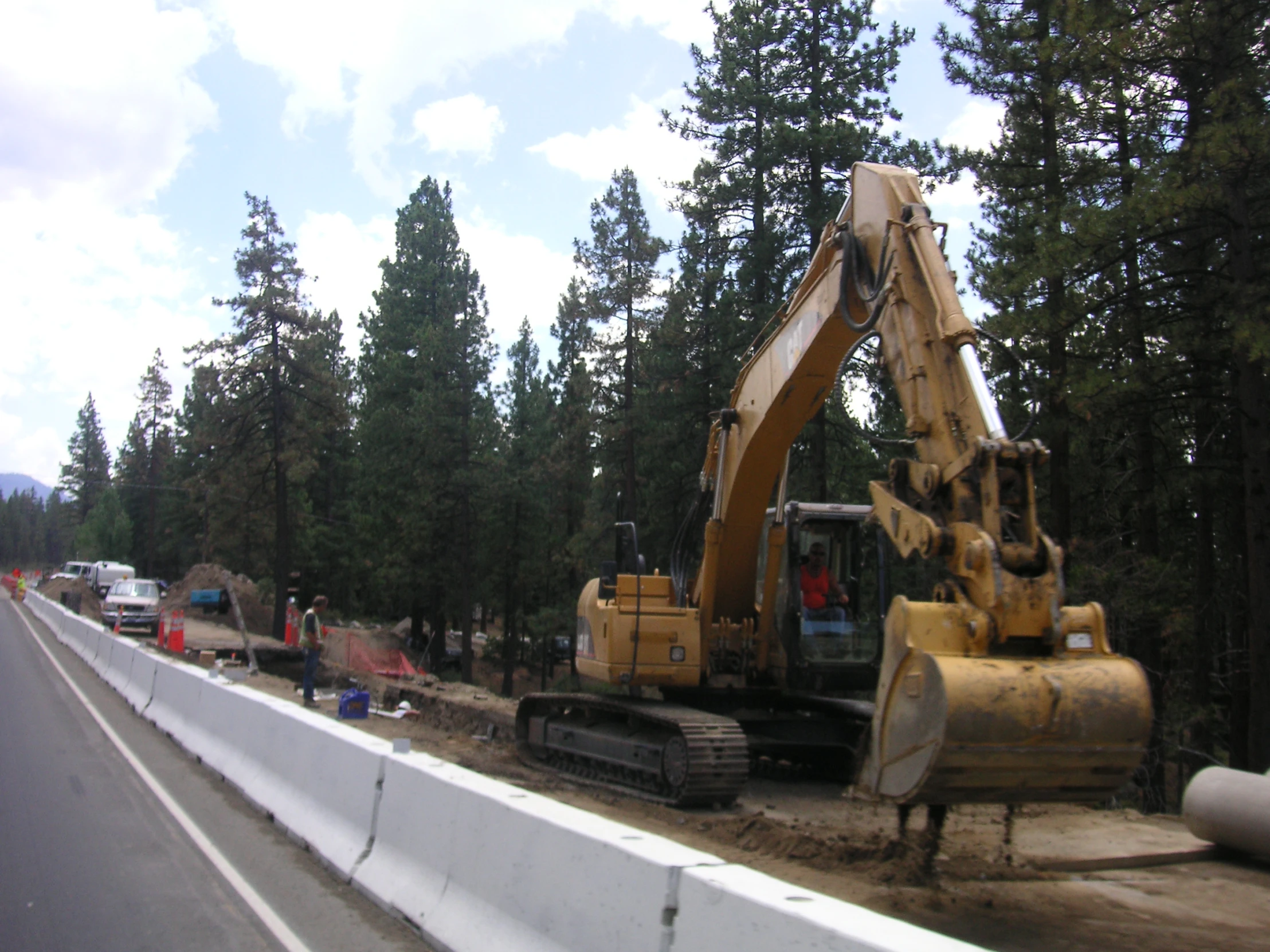 a backhoe is attached to an excavator to keep people out of a road construction site