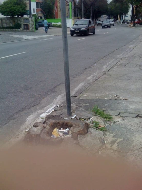 the sidewalk has trash on it and is near a street sign