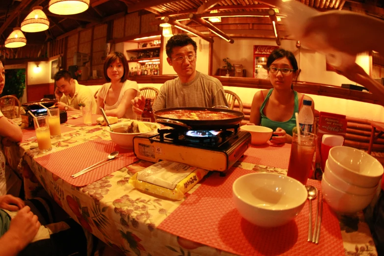 five asian adults are sitting at the dining table