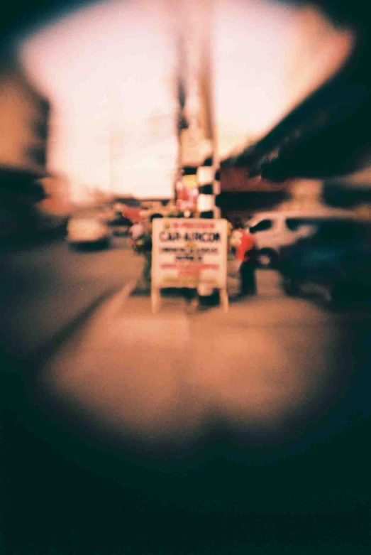 a blurry po shows several cars and buildings along a street