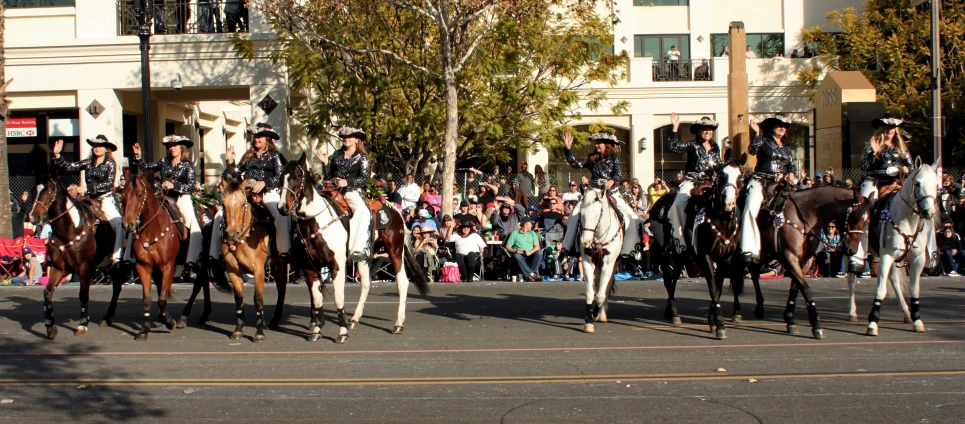 there are many horse riders that are walking down the street