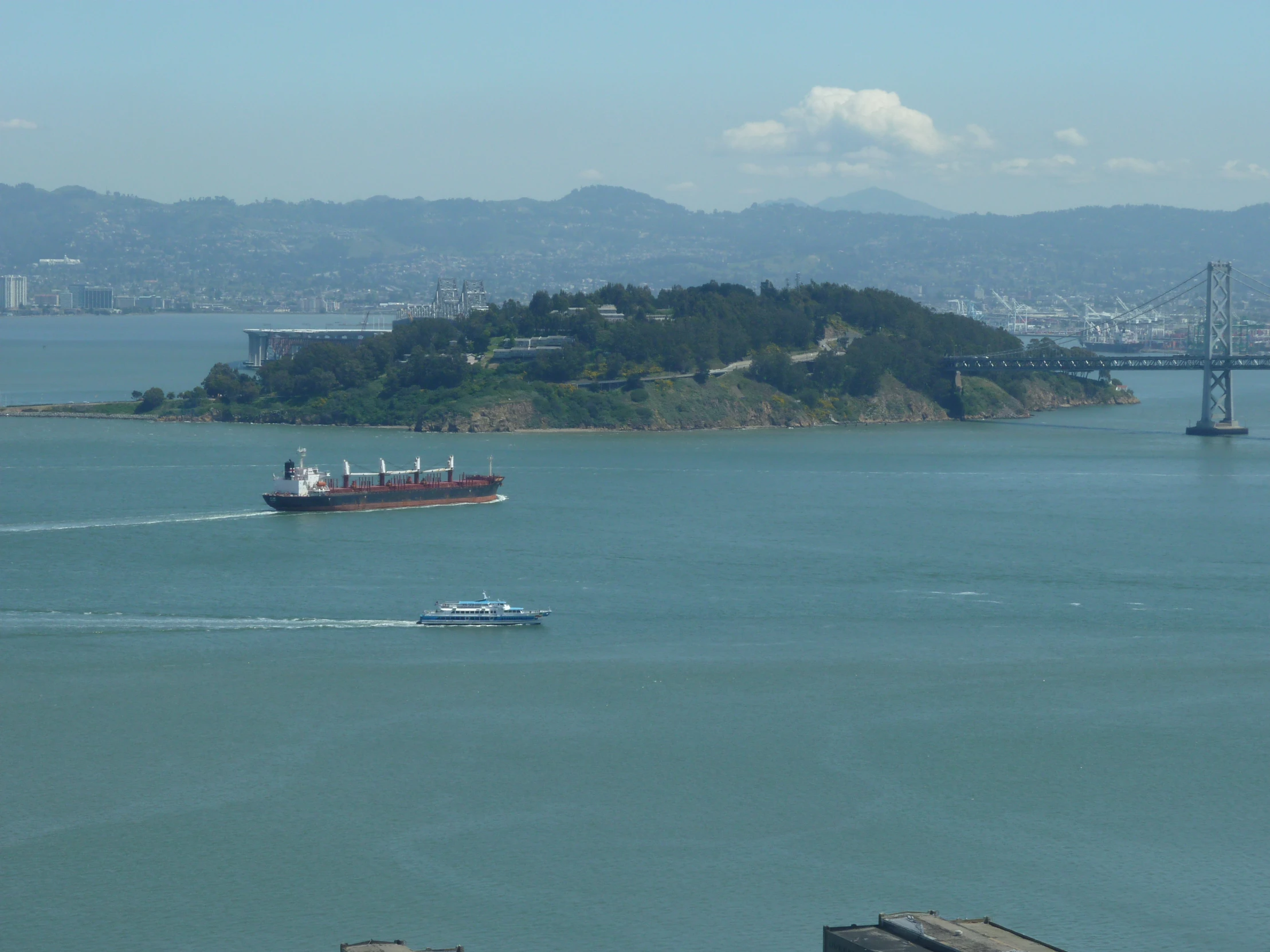 a ship passing by with a large bridge and a body of water