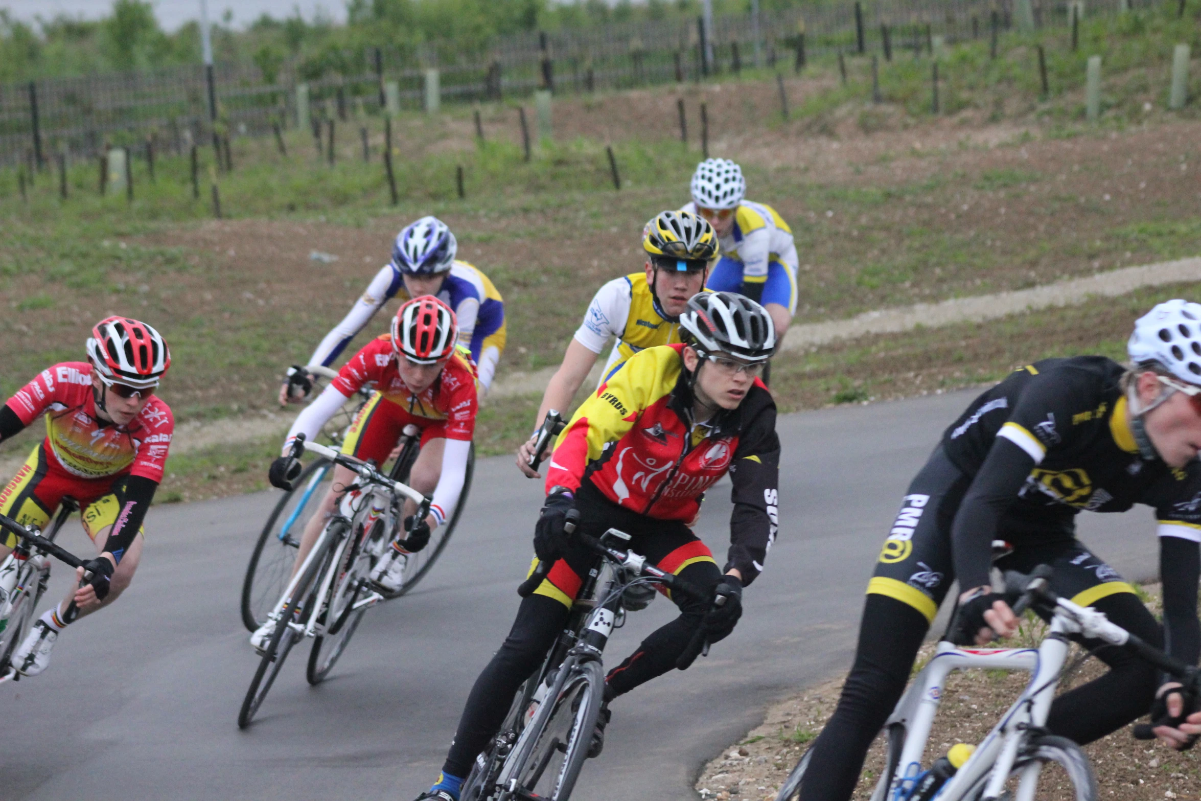 four bicyclists going around a corner on their bikes