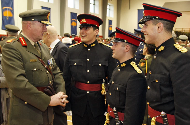 group of men in uniform standing in front of flags