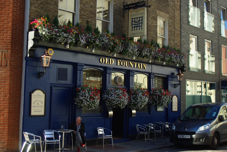 people are outside of a restaurant that has a window planter