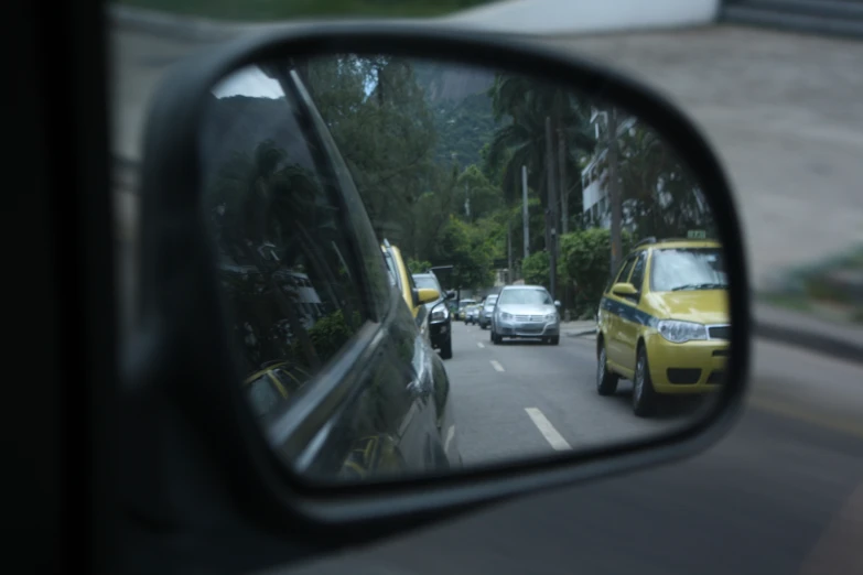 a mirror on a car shows a street filled with traffic