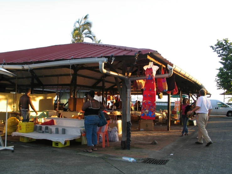the people are selling items from a covered stand