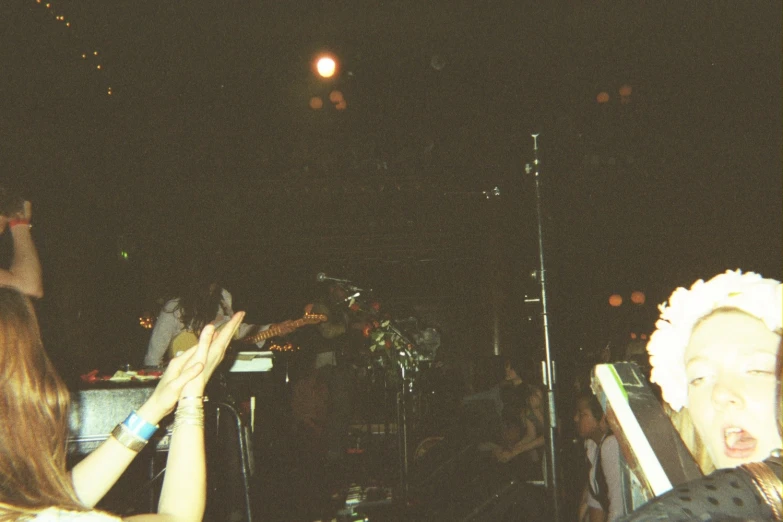 two women are reaching up toward a microphone