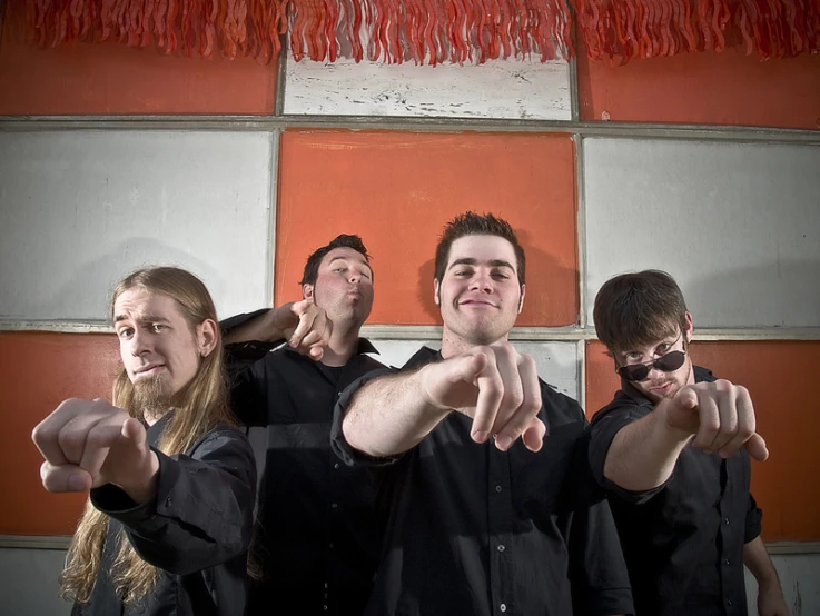 four young men pointing their guns at the camera