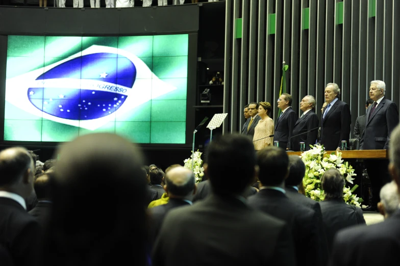 a group of men standing at a podium in front of a crowd