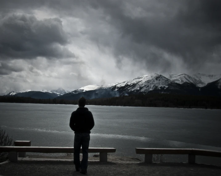 a man standing at a bench looking out onto the water