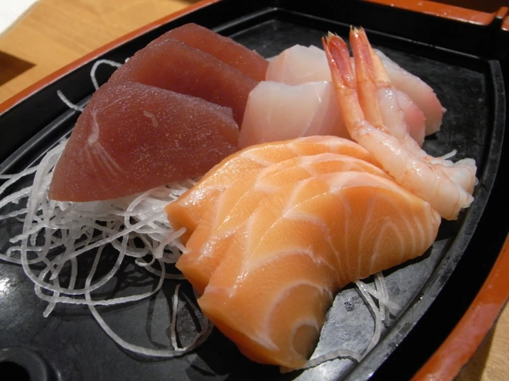 some fish on a small plate with sushi