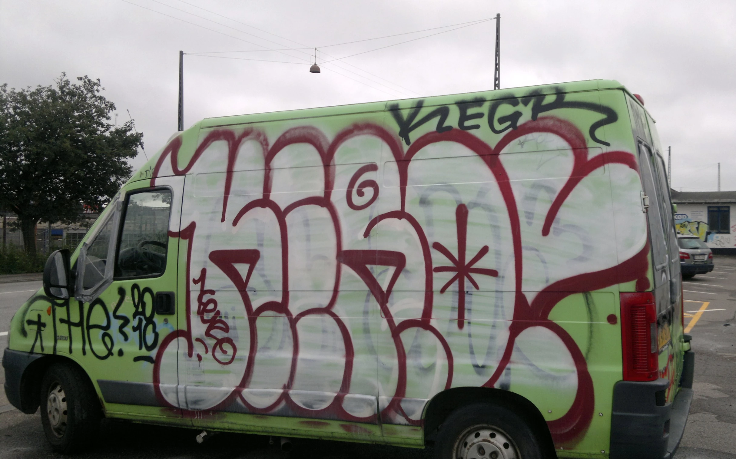 graffiti on the side of a van parked in a parking lot