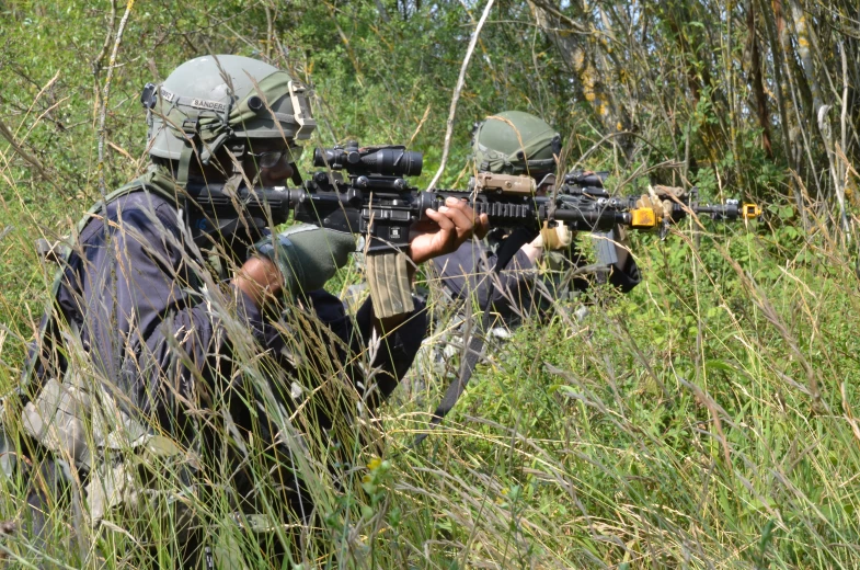 soldiers in the woods with their rifles ready to be s