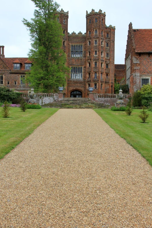 the walkway has a gravel path between two buildings