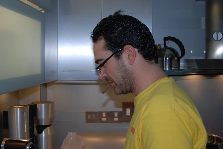 a man wearing glasses and looking in the oven