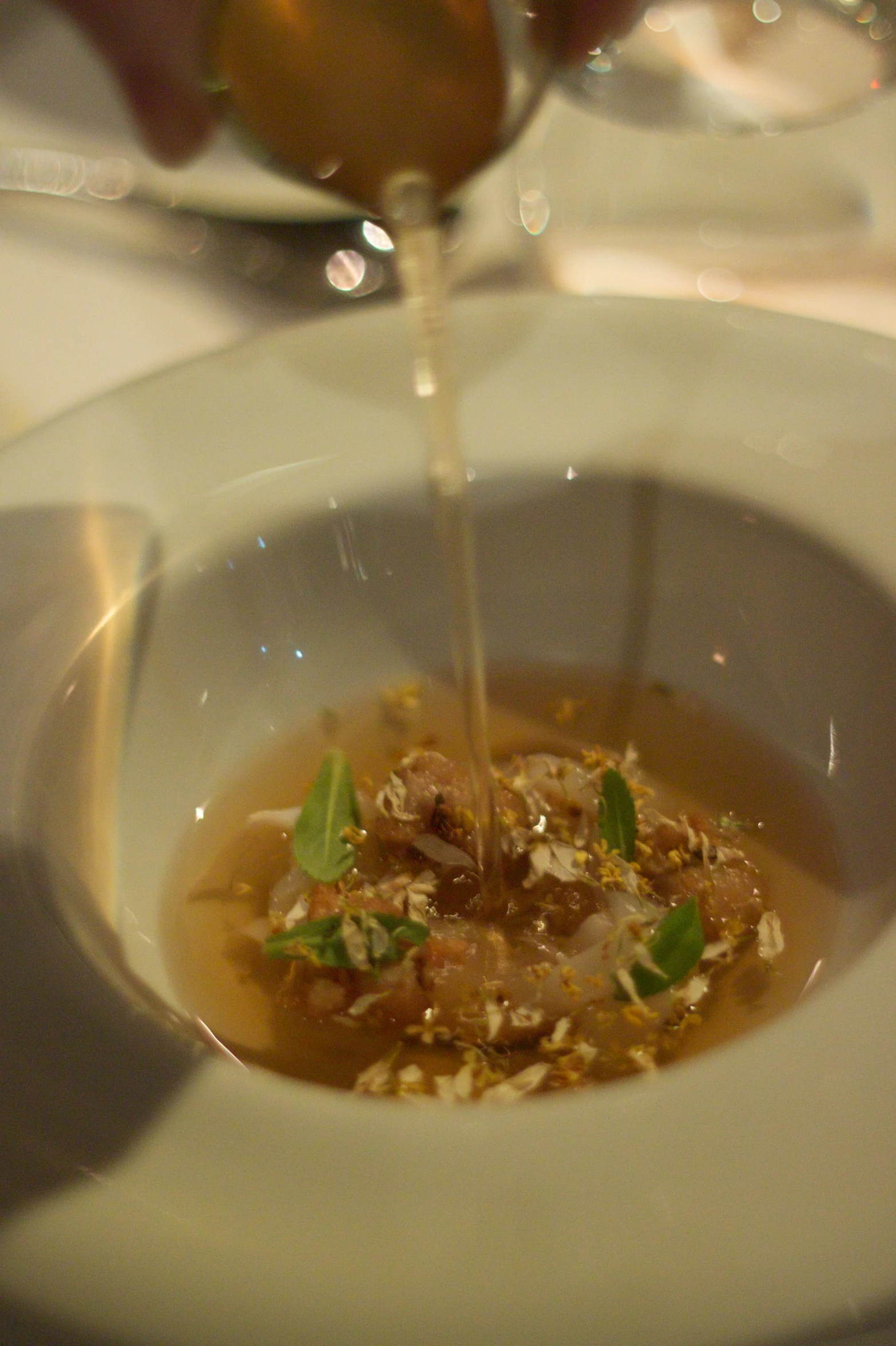 a person pouring wine into a small bowl