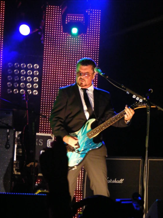 a man playing an electric guitar on stage