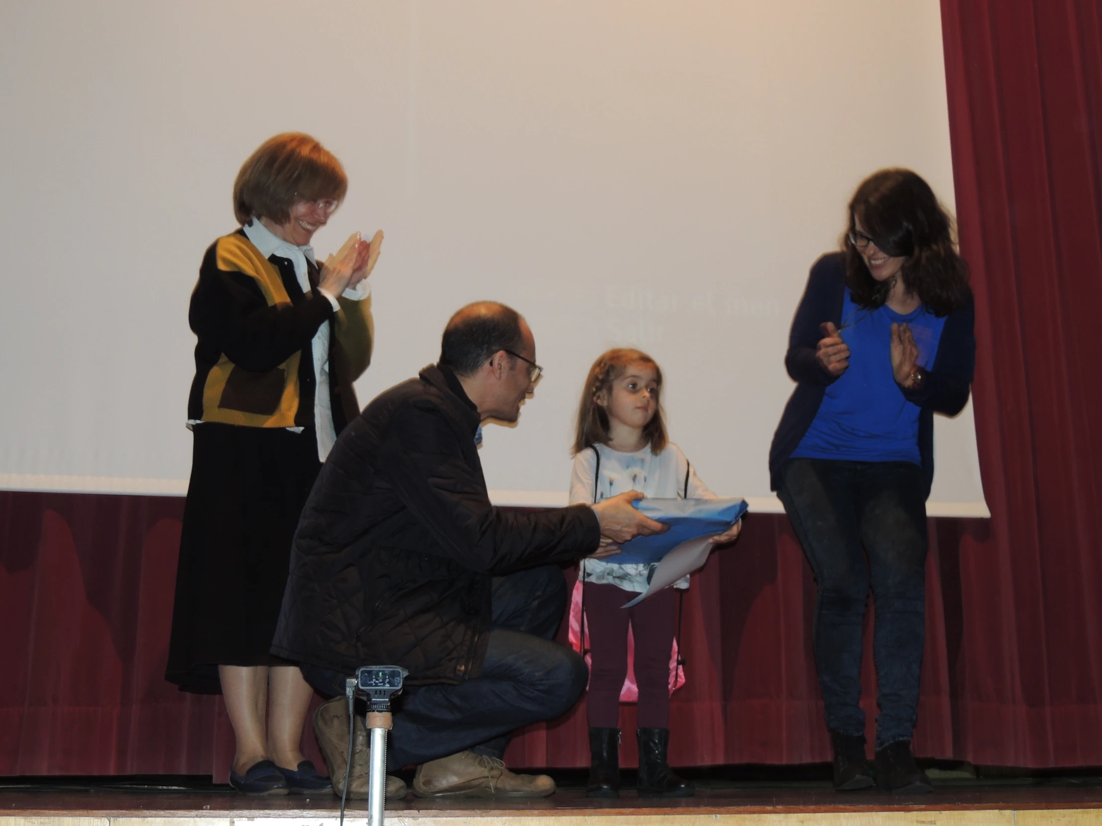 a man, woman, and girl are on stage