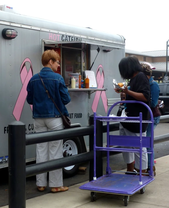 people waiting for food at a booth at a park