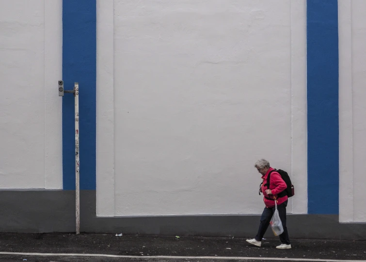 the back view of a person walking down the sidewalk