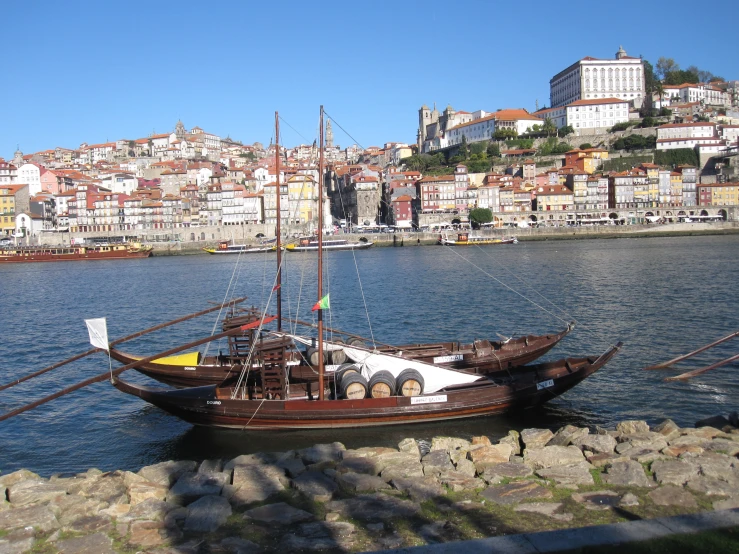 a large boat in the middle of a river with a town in the background