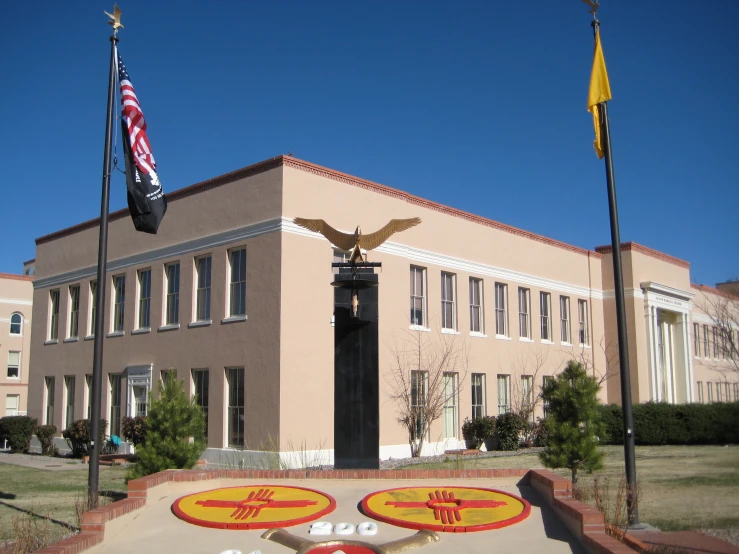 an eagle sculpture and flag on the corner of a building