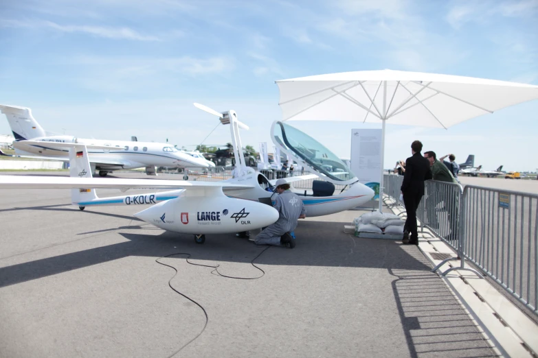 people look at the small air plane while two others look on