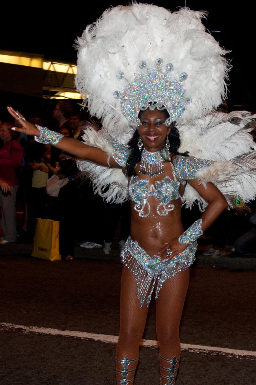 an attractive woman in elaborate clothing standing in the street