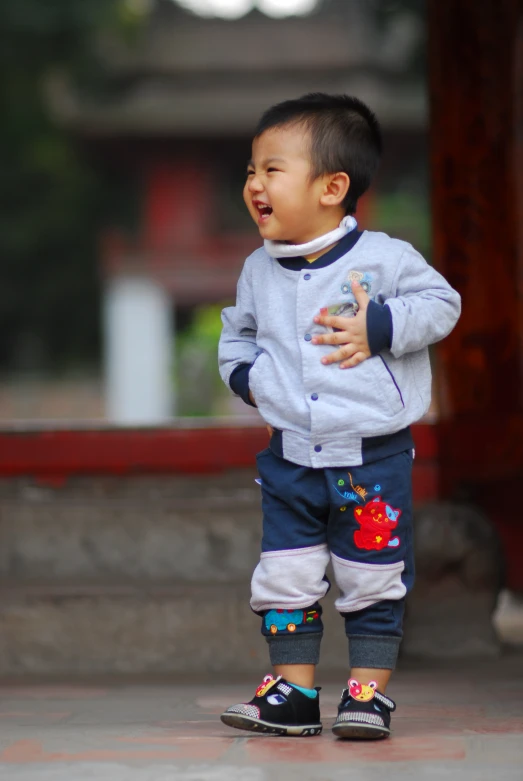 the small child is walking in front of a structure