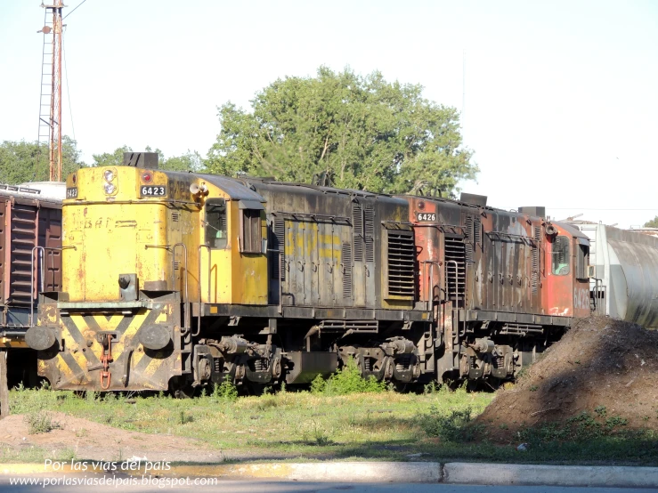 yellow train engine sitting in an old train yard