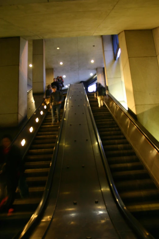 people are riding down an escalator in a building