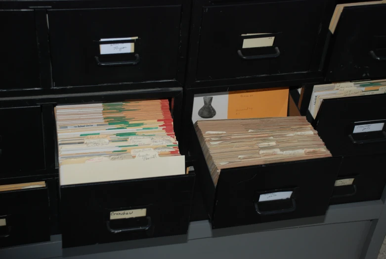 four file drawers with files and files on top of them