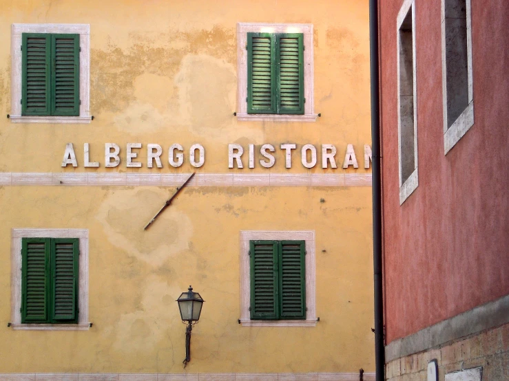 a building with green shutters on the side