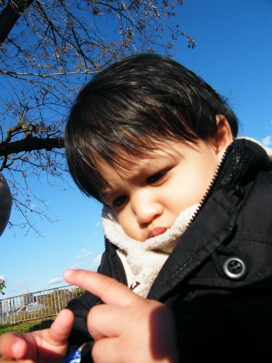 a boy in a park with trees in the background