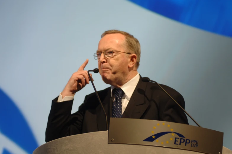 an older man gives a presentation on a podium