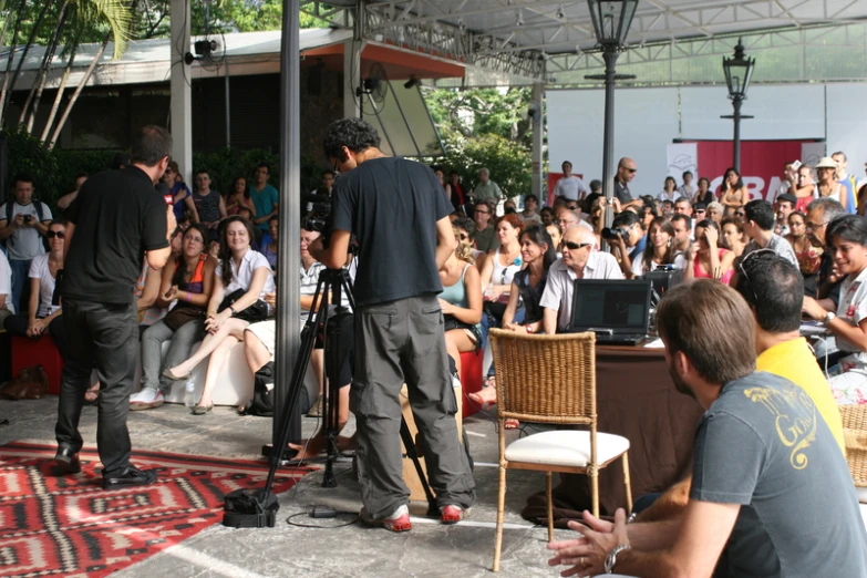 a man on a video camera in front of a crowd