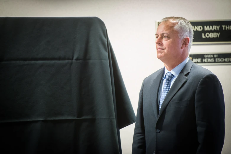 a man with a suit and tie standing next to a tee shirt