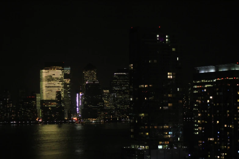 view of buildings with lights and reflections on water